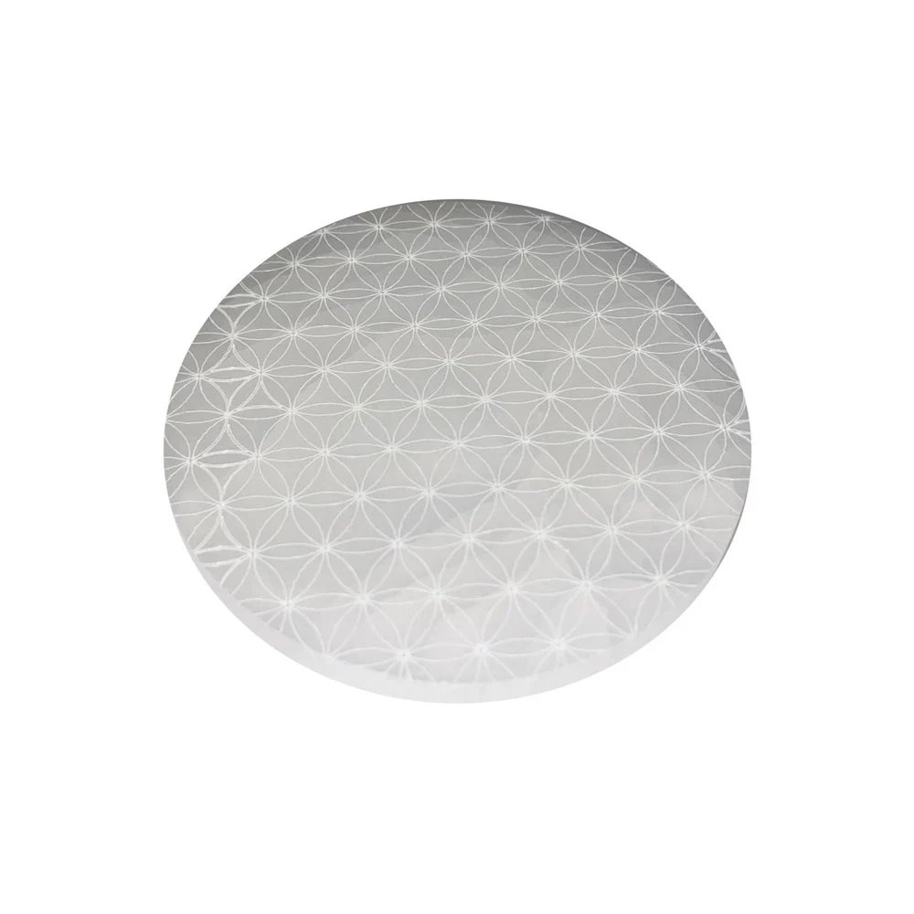 A round polished selenite charging plate engraved with a Flower of Life pattern
