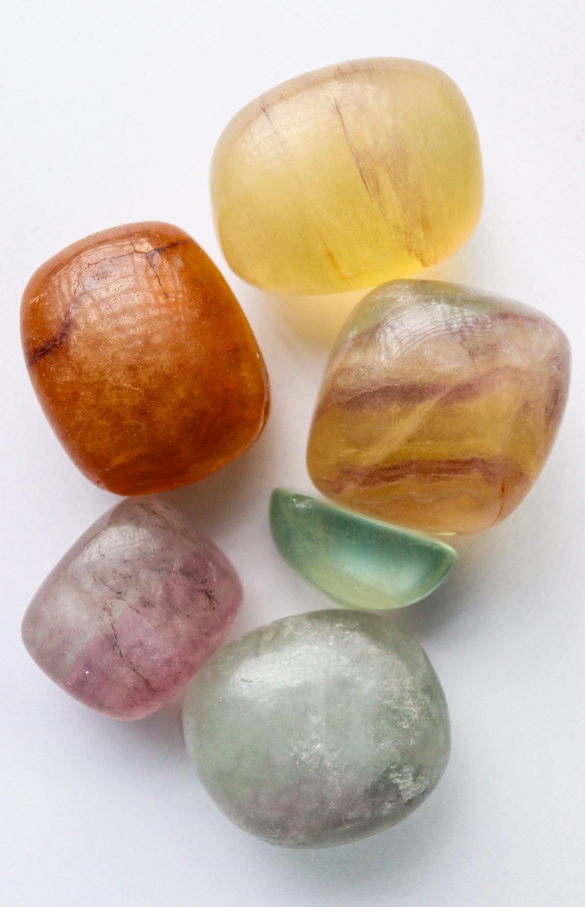 Seven chakra crystals laid out in rainbow colour order
