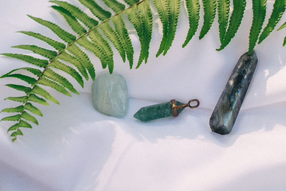Soft, calming healing crystals arranged with a fern leaf