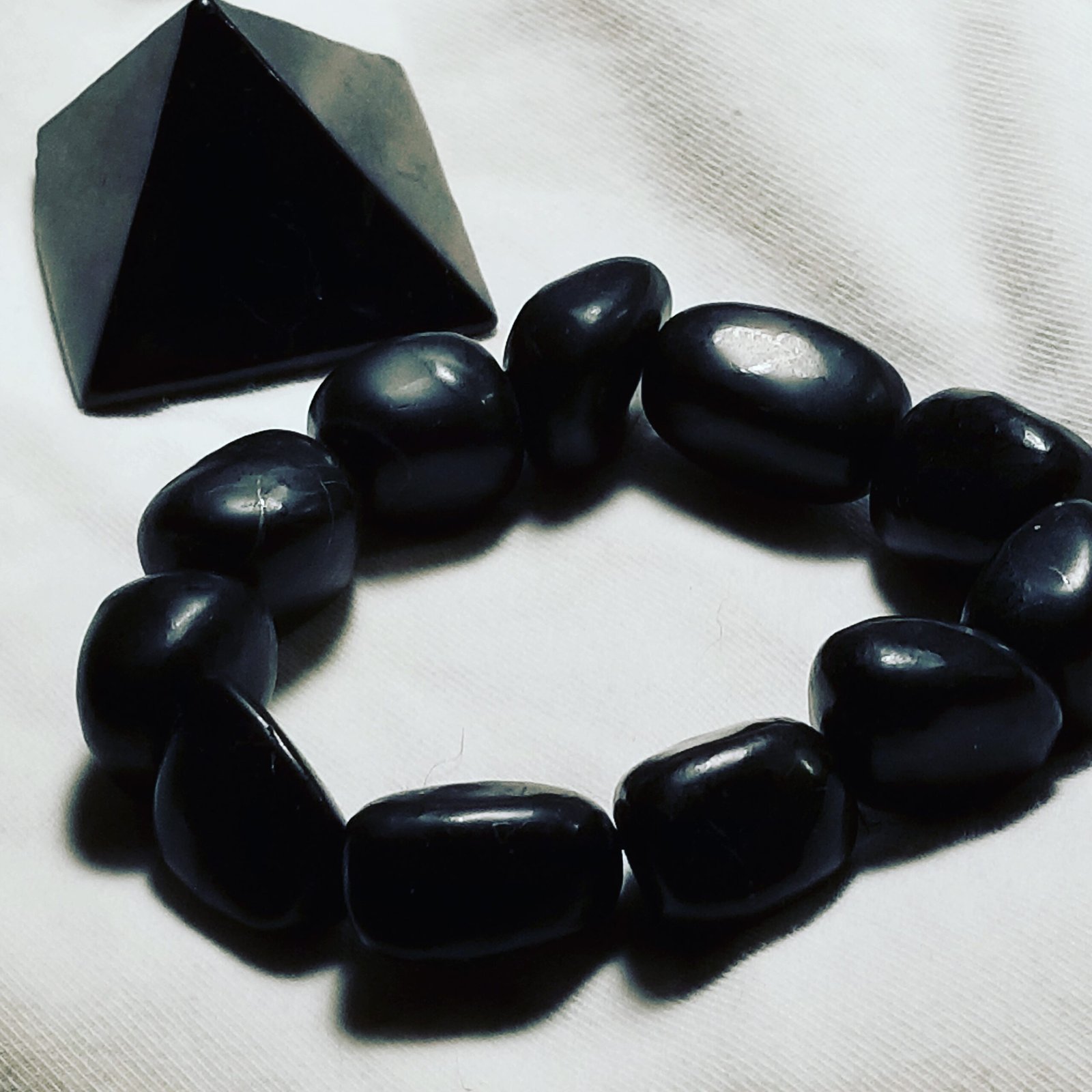 Polished black shungite pyramid, a carbon-rich rock from Karelia, Russia